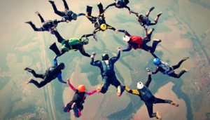 people holding hands while sky diving