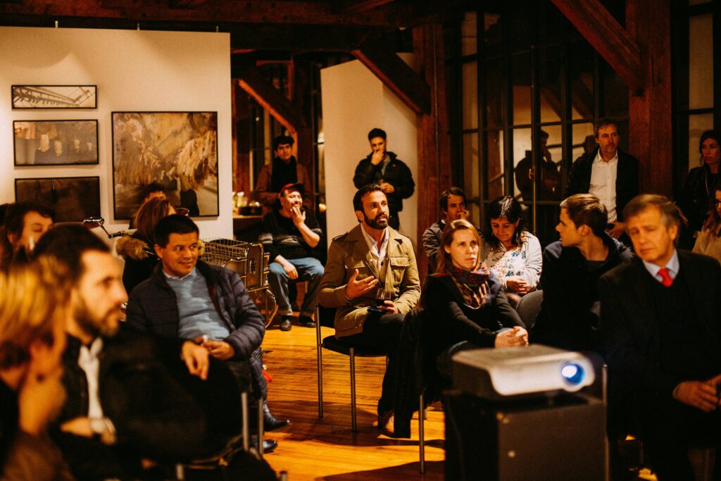 People in the audience sitting in chairs in a network meeting