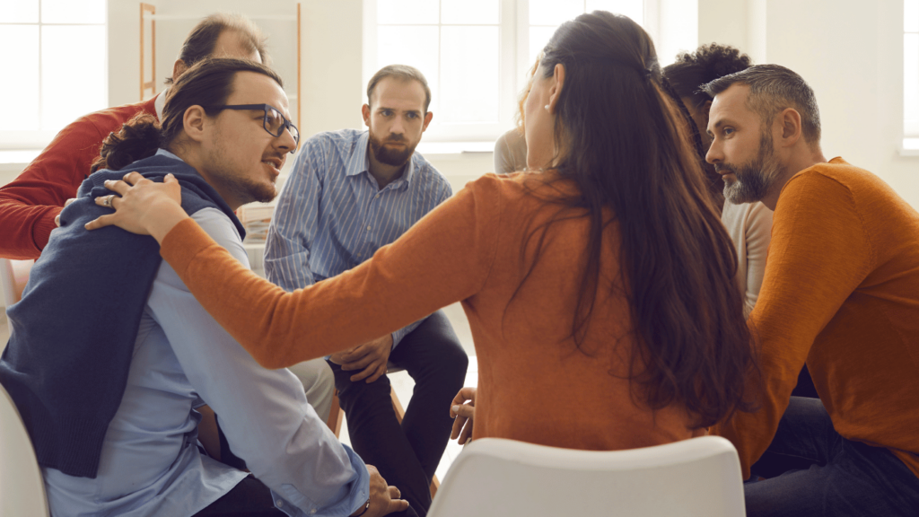 a group of seven people of both men and women sitting in a circle and discussing