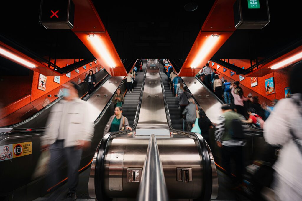 Two escalators full of people in motion, going about their day.