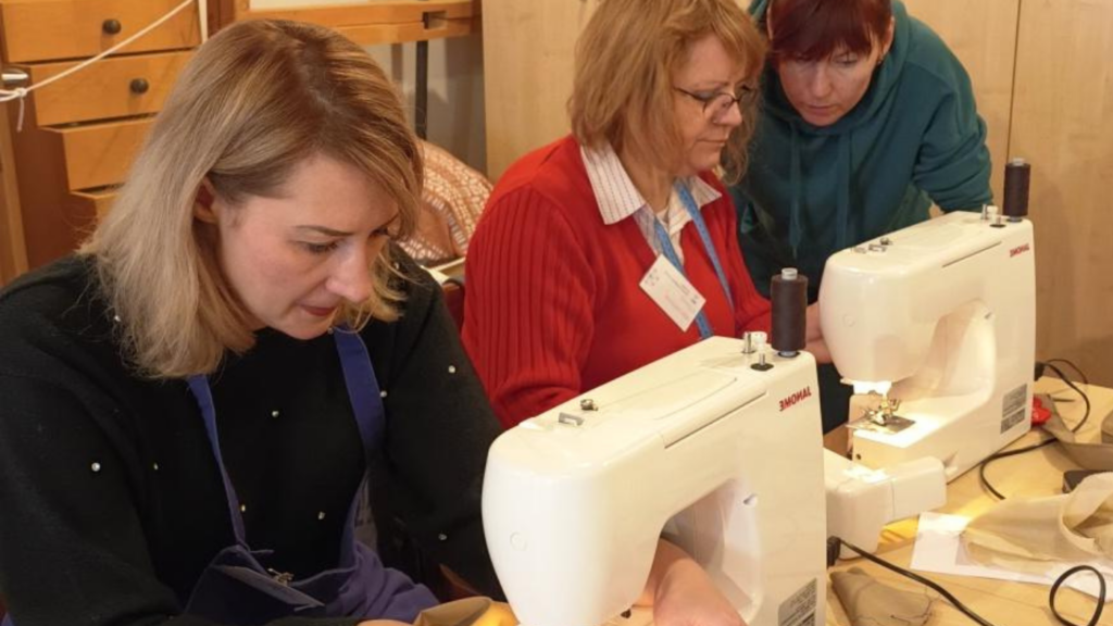 Three women working on sewing machines.