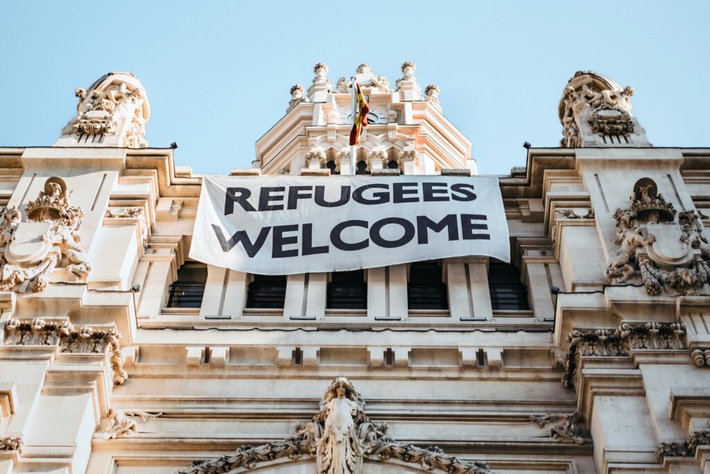 Sign on a building saying "Refugees welcome".