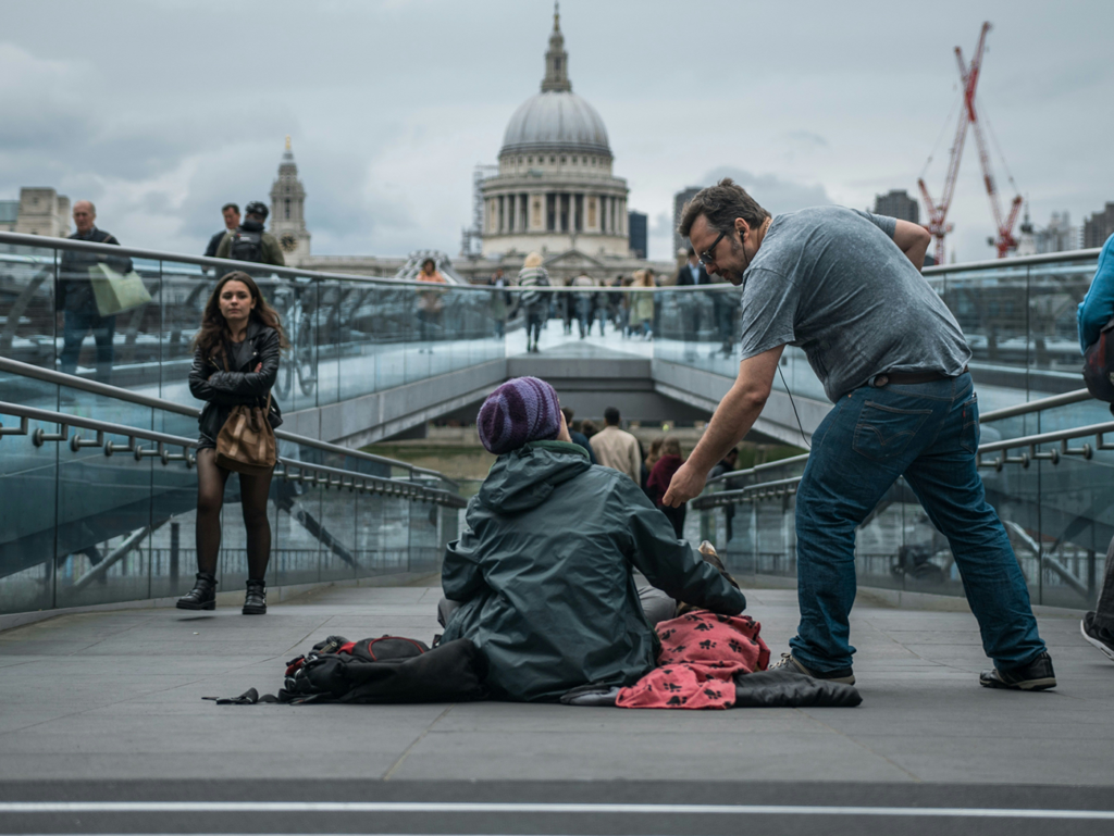 A man giving money to a homeless person.